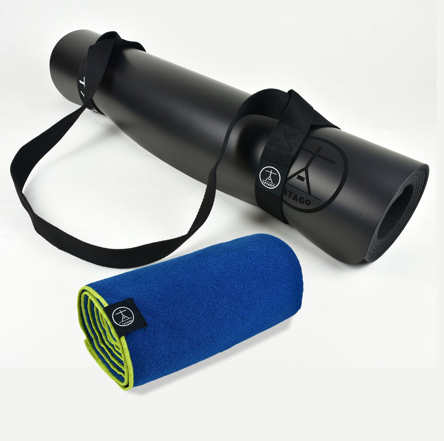 Extra-large black yoga mat with carrying strap shown with blue hot yoga towel, ideal for hot yoga, Bikram, and Pilates sessions.