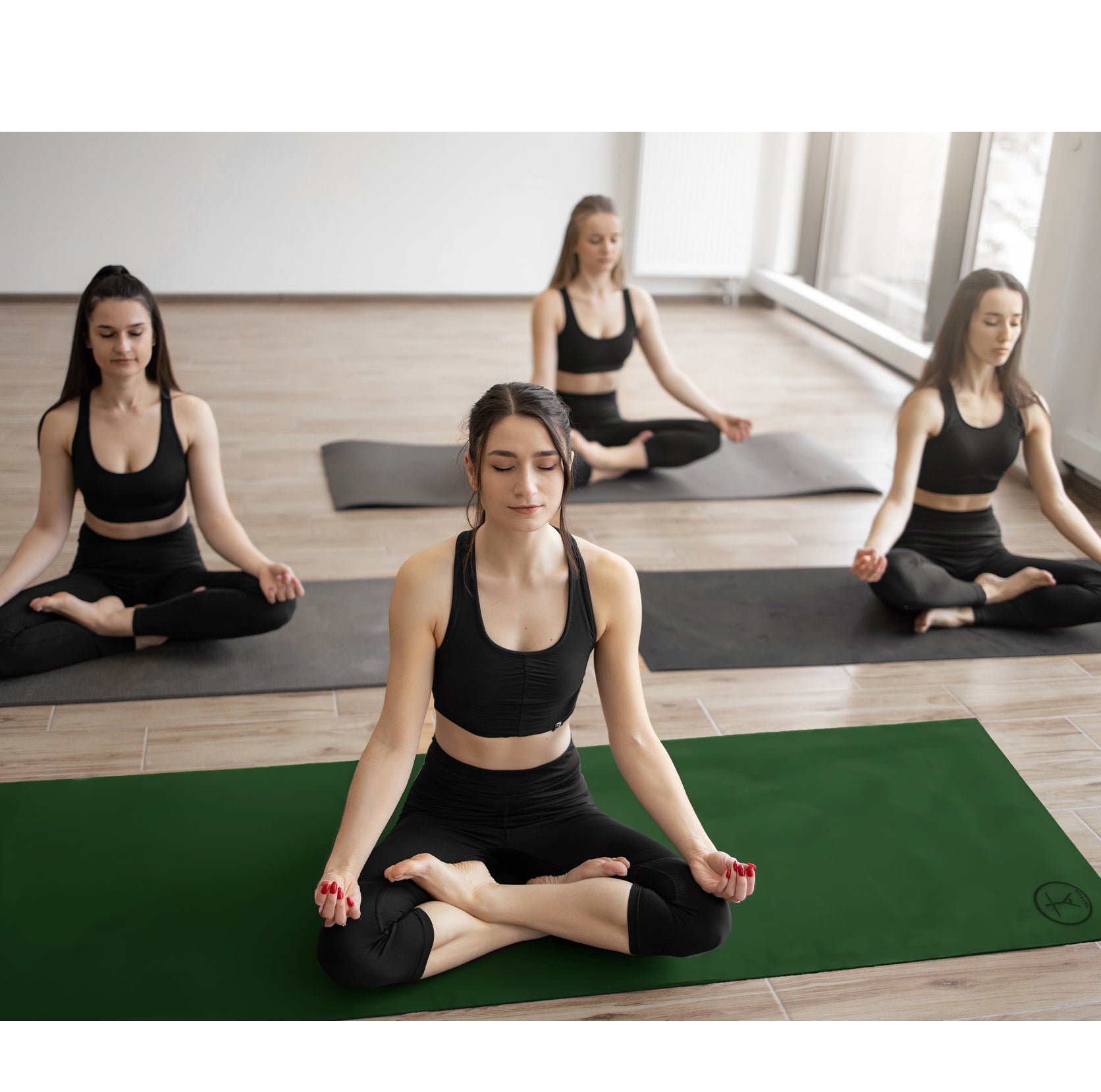Ladies practicing on Bikram yoga mat with Hot yoga towels in a studio