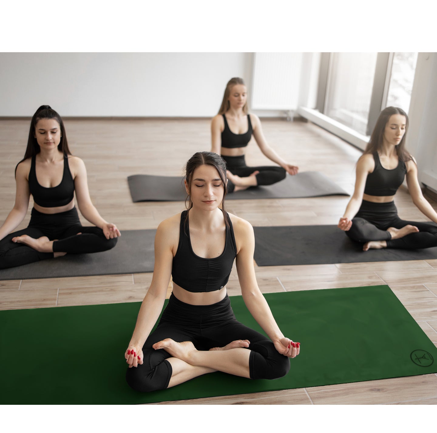 Ladies practicing on Bikram yoga mat with Hot yoga towels in a studio