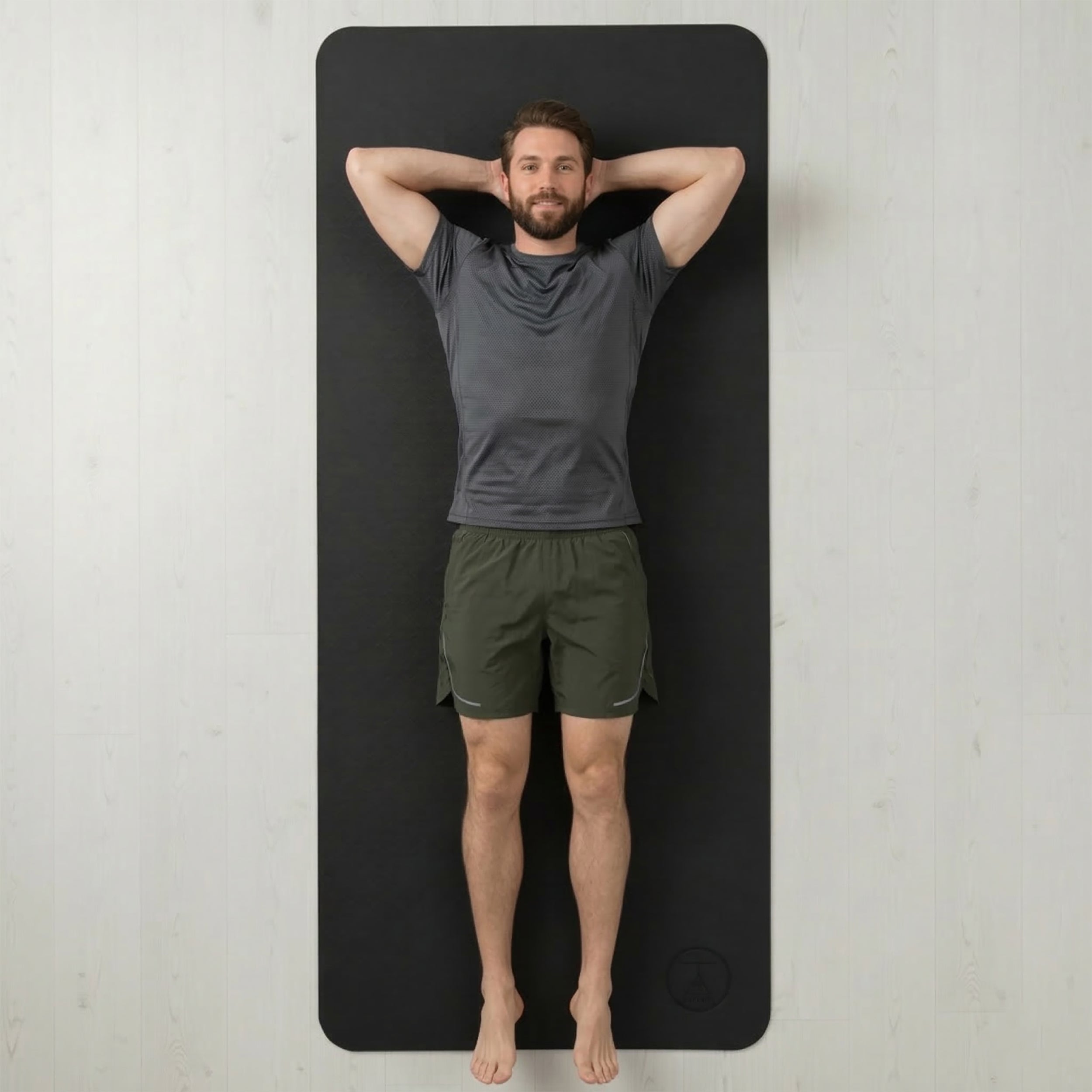 a extra large and super thick yoga mat next to a man to show size and dimesions.