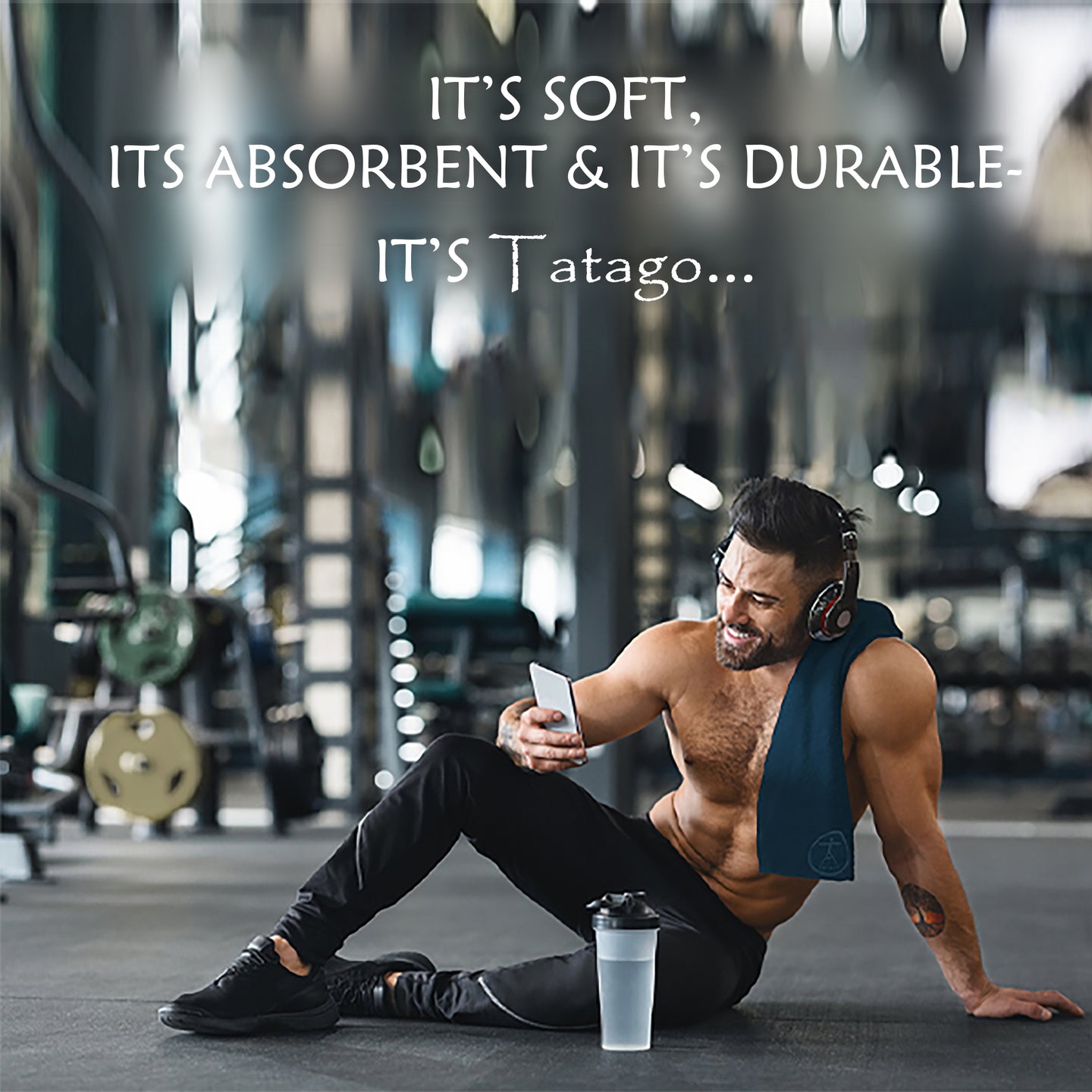 Microfiber gym towel
on a man with a fitness towel draped over his shoulder, holding a phone.