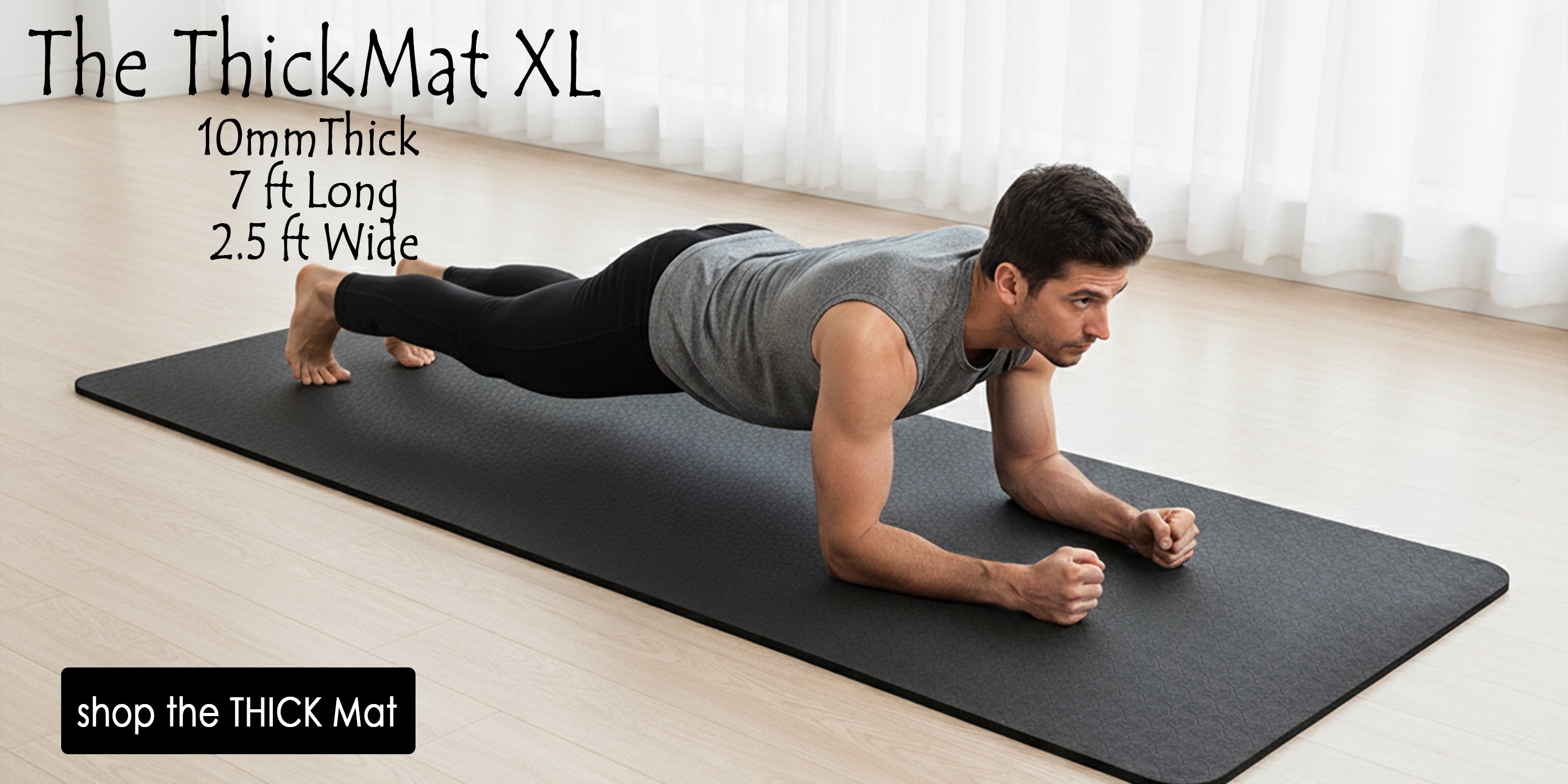 Man on extra large exercise mat thick and long and wide on a wood floor