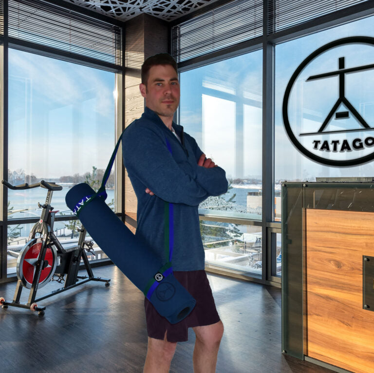 Man carrying yoga mat with strap over shoulder - Blu/Grn