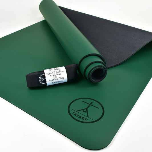 Natural rubber yoga mat rolled with carrying strap on studio floor (Green)