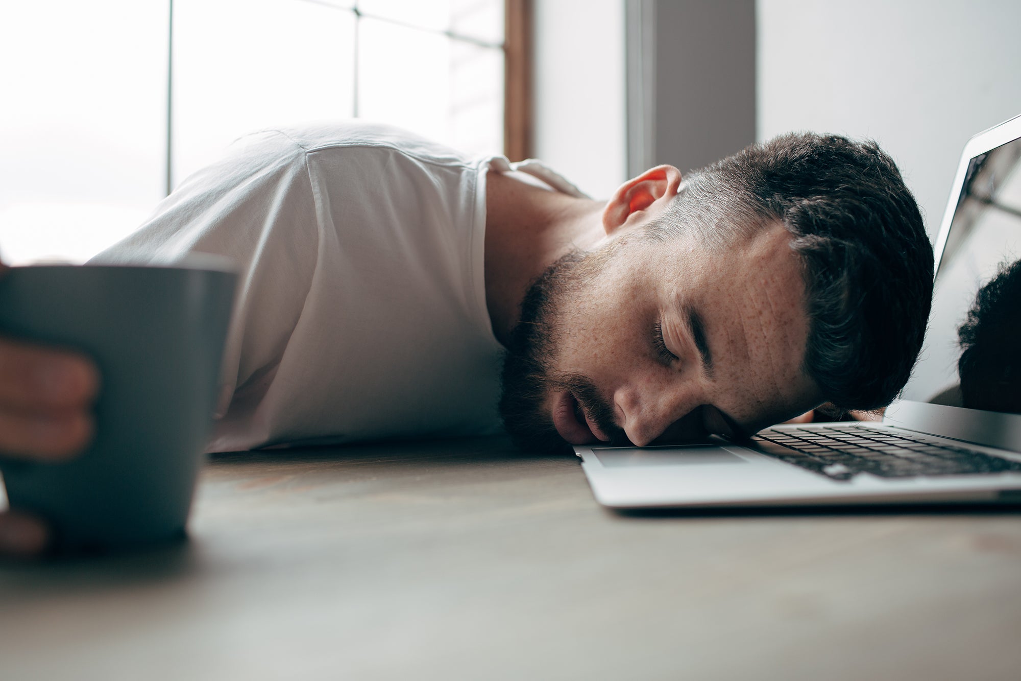 Man with lack of energy at desk with tatago yoga mat xl in backgoround