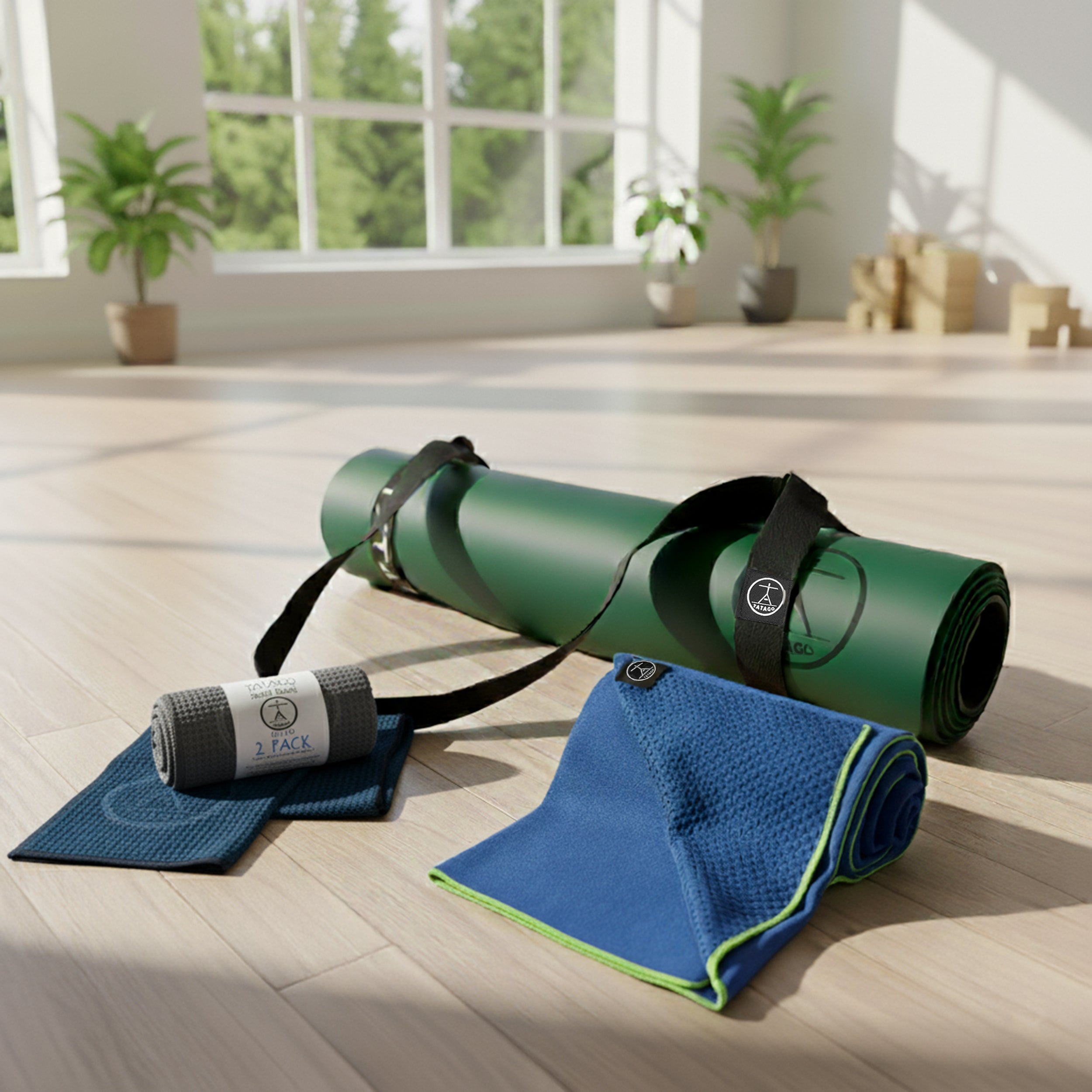 Good exercise mat bundle featuring XL natural rubber yoga mat with blue silicone-grip towel and microfiber sweat towels in a bright studio.