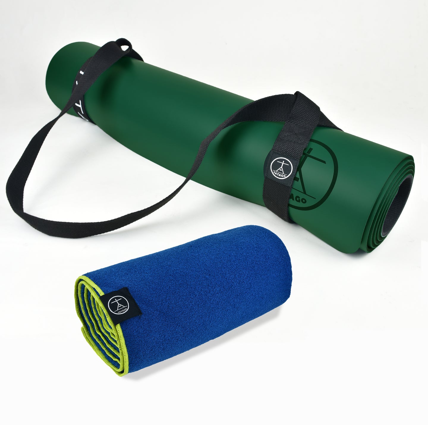 Largest yoga mat style XL natural rubber mat shown in bright studio with rolled blue hot yoga towel for home gym and Pilates training.