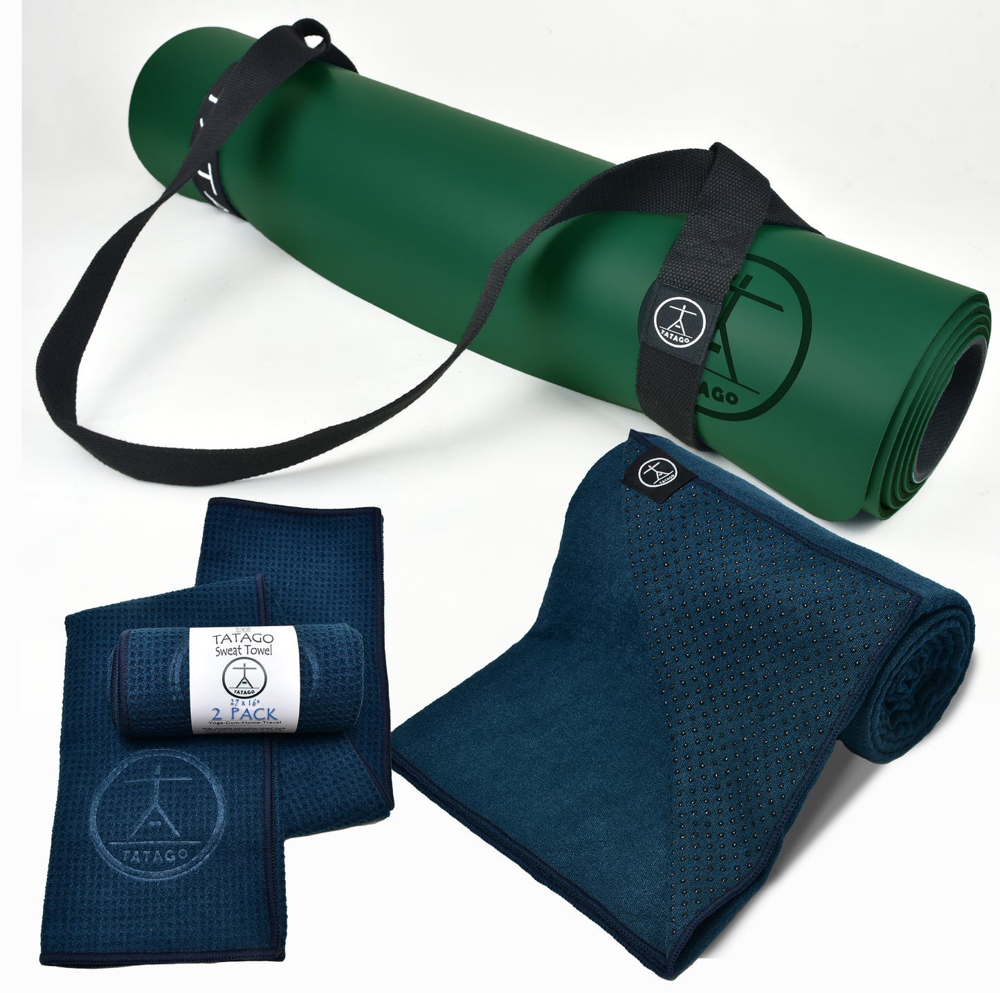 Rolled natural rubber yoga mat with yoga towel with grip and cotton yoga strap inside a bright studio, showing towel on yoga mat setup for warm yoga and hot yoga gear.
