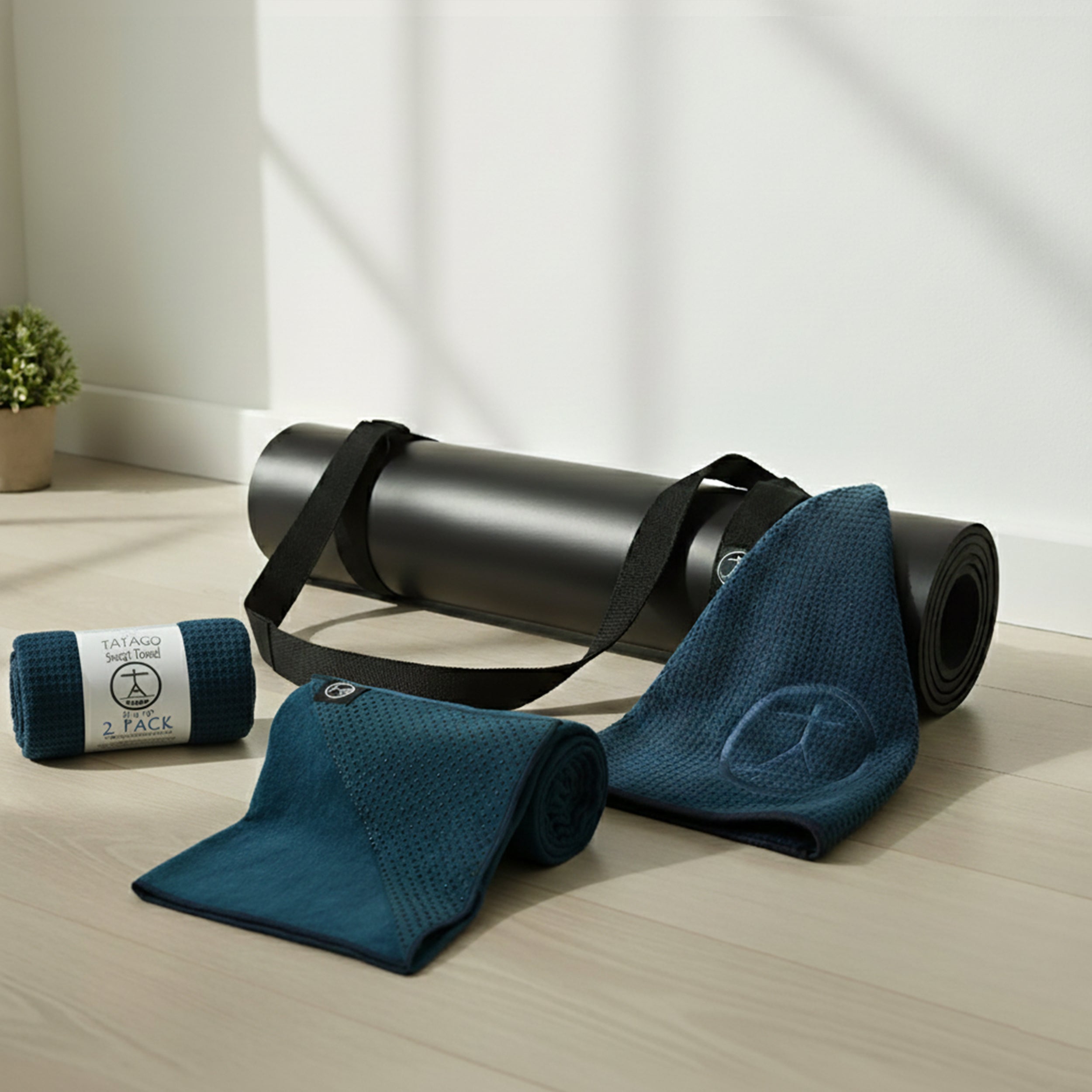 Non-slip yoga mat and towel set with carry strap shown in a bright home studio for hot yoga, Pilates, Bikram, and sweat-heavy practice.